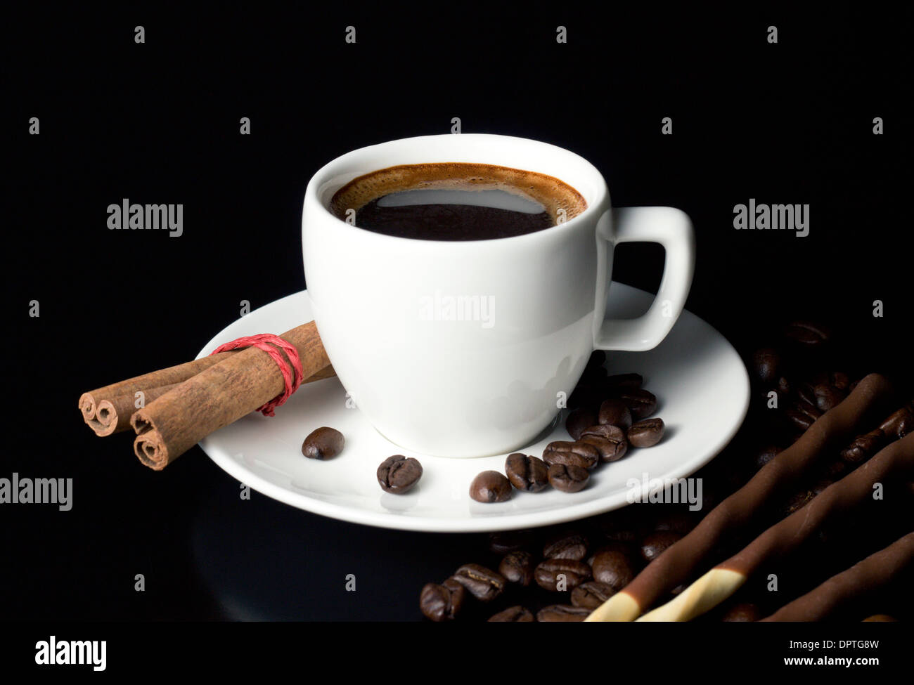 natural coffee cup with beans and chocolate sticks on black table Stock Photo