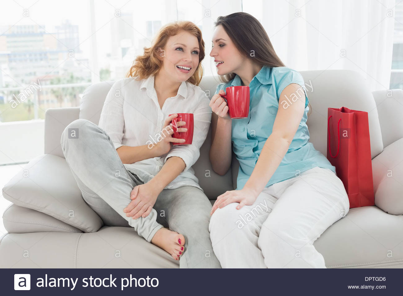 Две подруги в кафе. Девушки в одинаковых платьяэ. Два женщины в одном доме. Две девушки в одинаковых платьях. Две подруги беседуют в кафе.