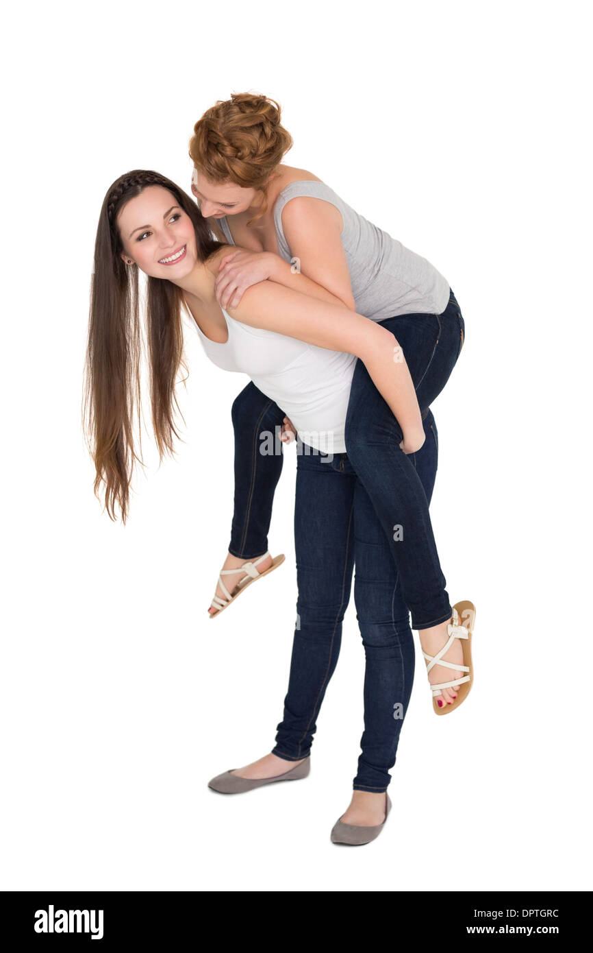 Full length of a young female piggybacking friend Stock Photo