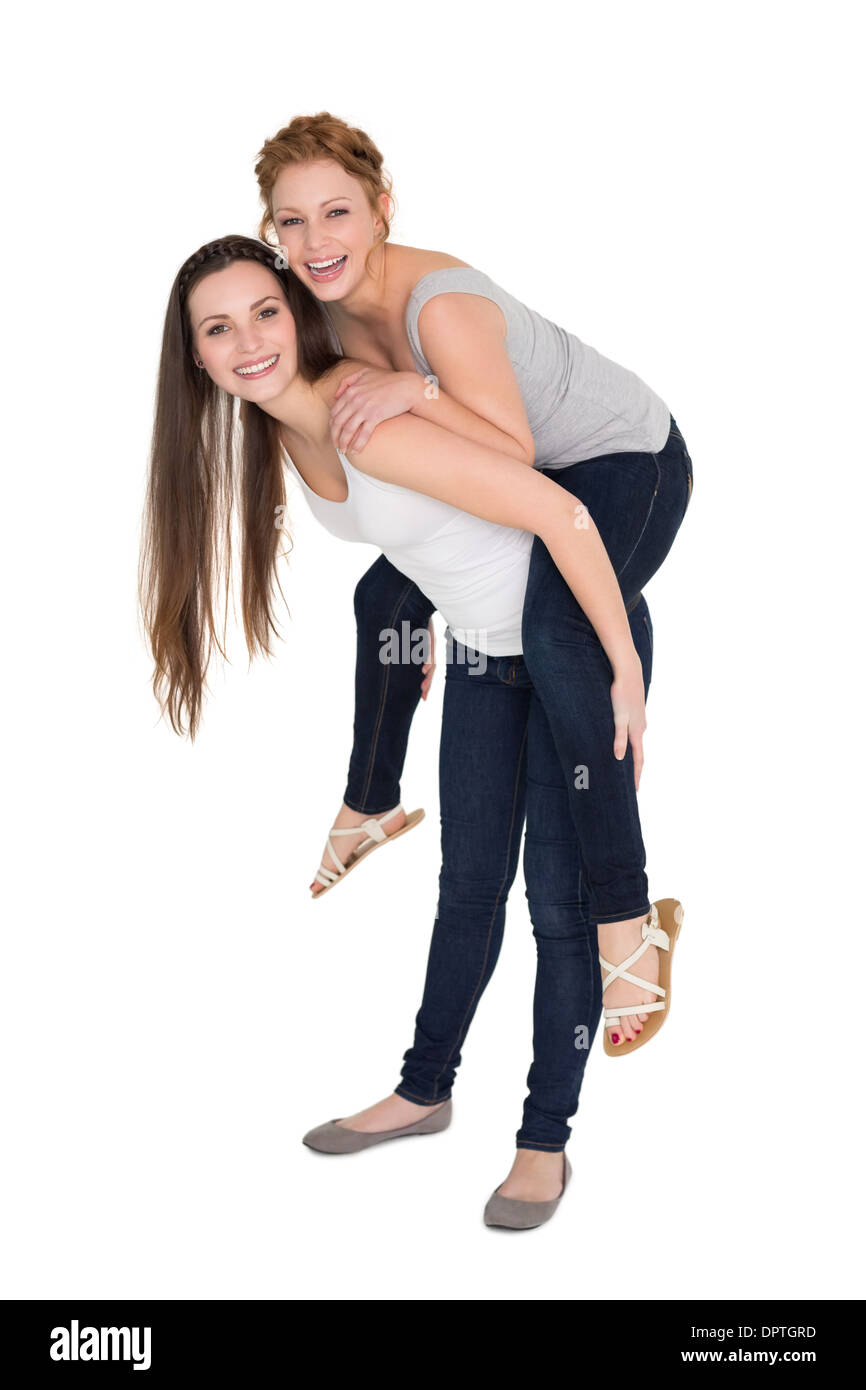 Full length portrait of a young female piggybacking friend Stock Photo