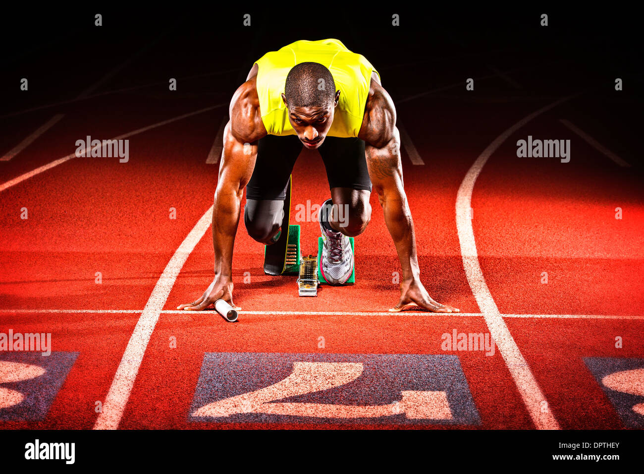 A wounded military veteran comes to set position in a track relay. Stock Photo