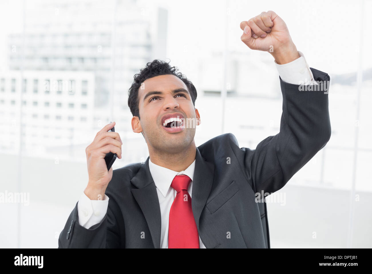 Businessman cheering with clenched fist as he looks up Stock Photo Alamy