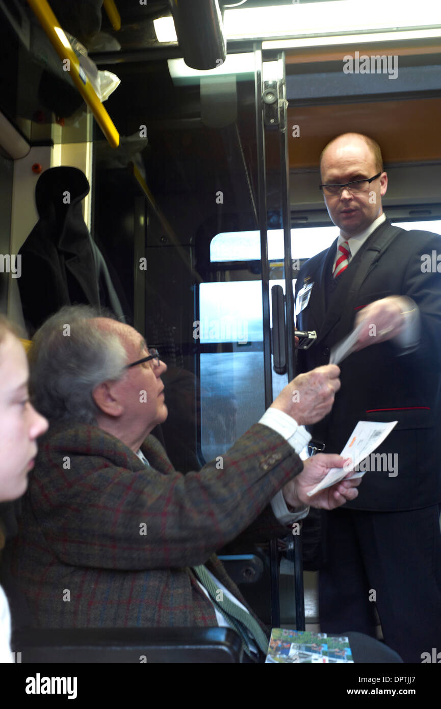 A passenger on the Prague to Bratislava train hands his ticket to a guard for inspection Stock Photo