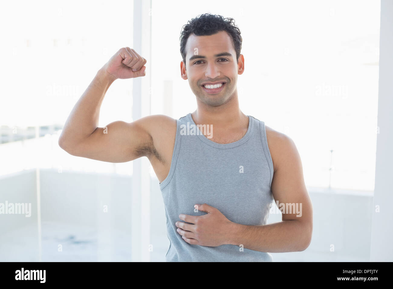 Portrait of a fit man flexing muscles in fitness studio Stock Photo