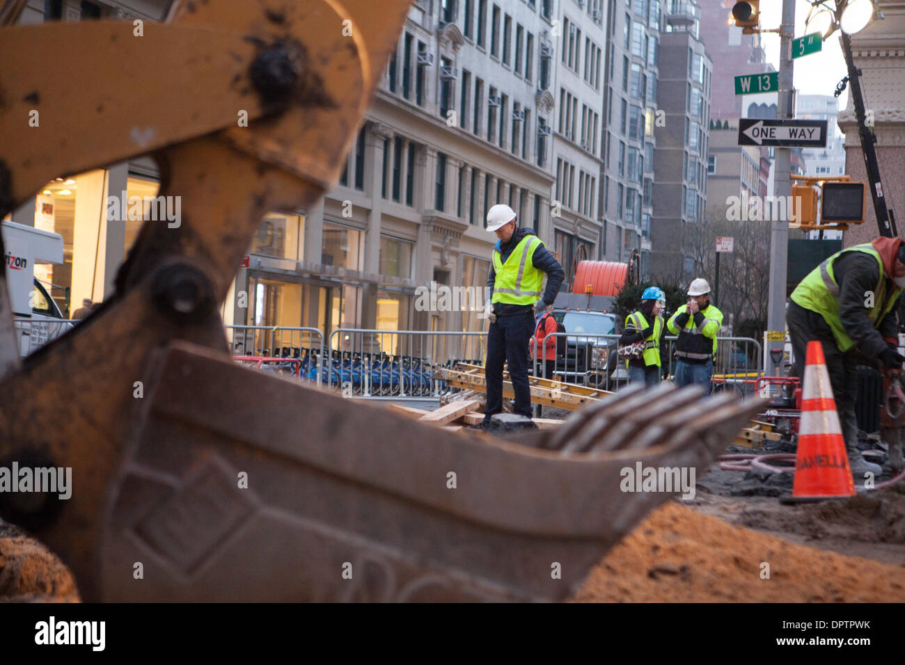 New York, USA. 15th January 2014. Crews from the DEP and ConEd continue to excavate to locate a water main break that flooded 5th Ave in Greenwich Village and left several nearby buildings without water.  Workers estimate it will take several days to locate and repair the break. Credit:  Mansura Khanam/Alamy Live News Stock Photo