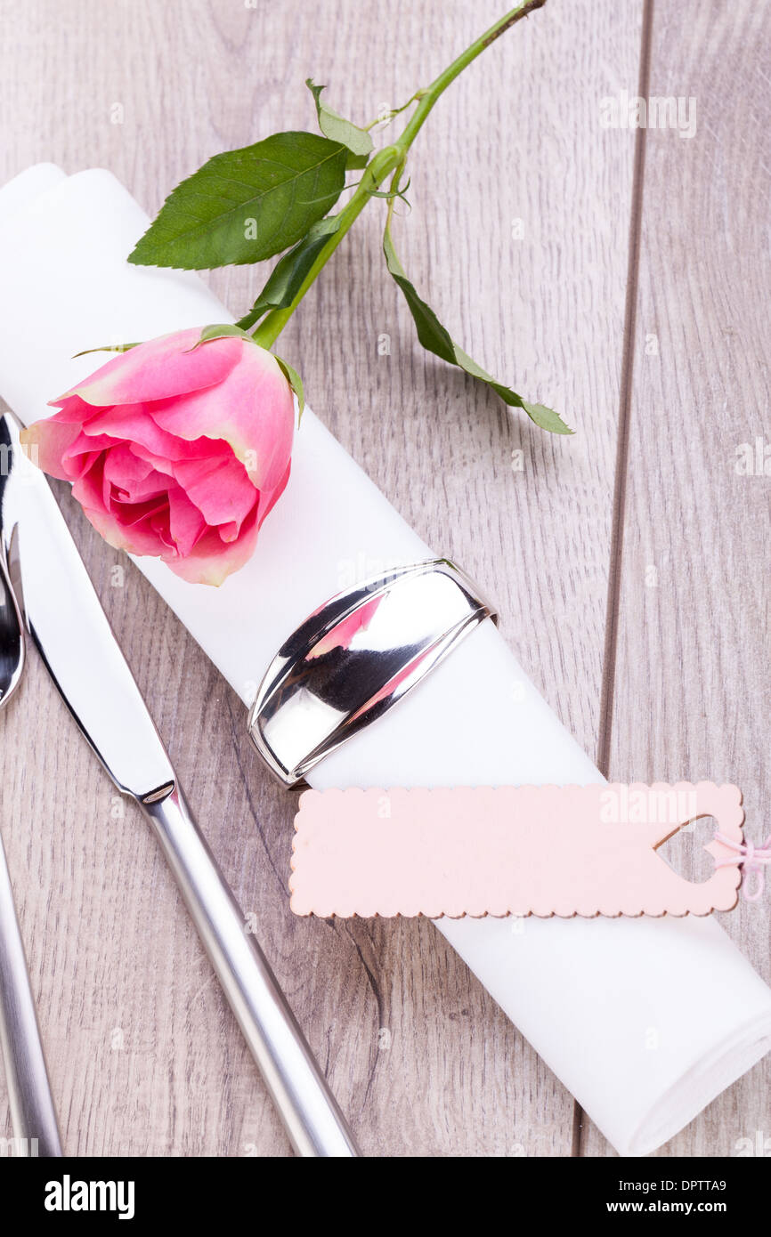 Romantic formal elegant table setting with a single pink rose and ...