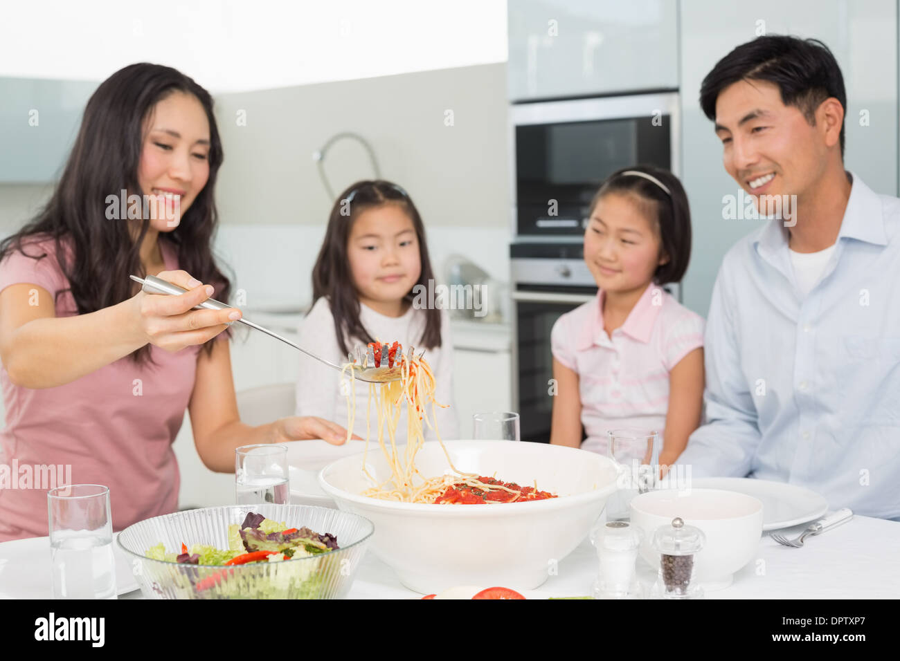 Happy woman serving spaghetti for the family in kitchen Stock Photo Alamy