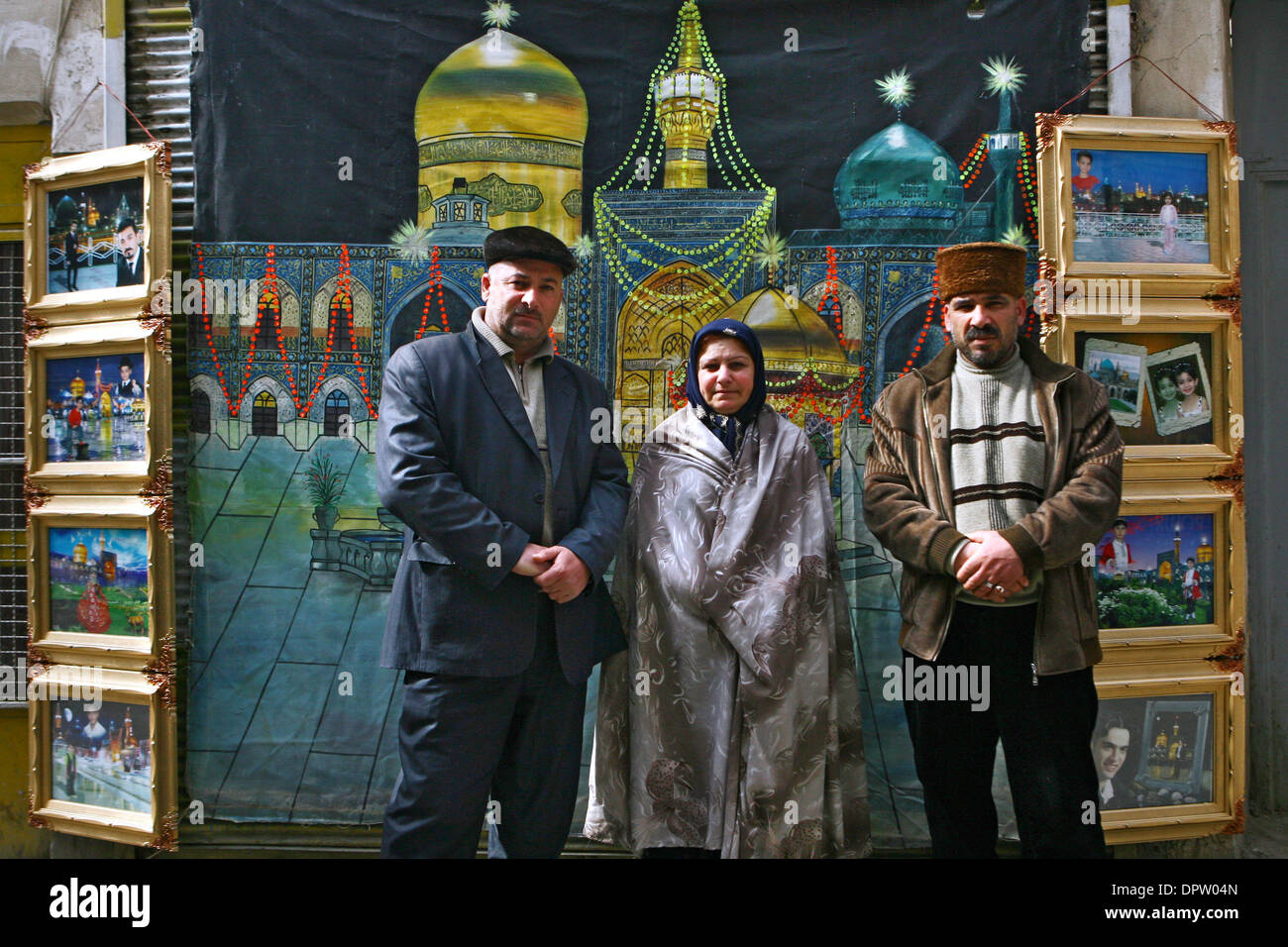 Feb 19, 2009 - Mashad, Iran - Iranian Shiite Muslim family pos for photographer in front of a backdrop of at Shiites' 8th Imam (Imam Reza's) holy shrine in the city of Mashad 574 miles northeast of Tehran. People have their photos taken which later on Photoshoped with images of the inside of Imam Reza's resting place. Photography is prohibited inside and this allows people to take  Stock Photo