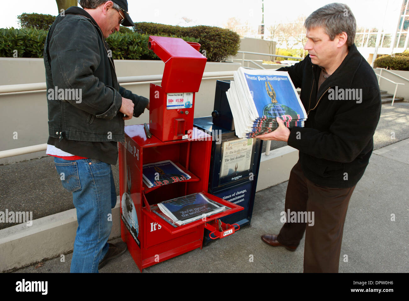 Mar 17, 2009 - Seattle, Washington, USA - A worker from the Seattle Post-Intelligencer fixes a jammed newspaper box.  The Post-Intelligencer printed its last newspaper today.  Hearst Corp., which owns the 146-year-old P-I, said Monday that it failed to find a buyer for the newspaper, which it put up for a 60-day sale in January after years of losing money. The P-I's roots date to 1 Stock Photo