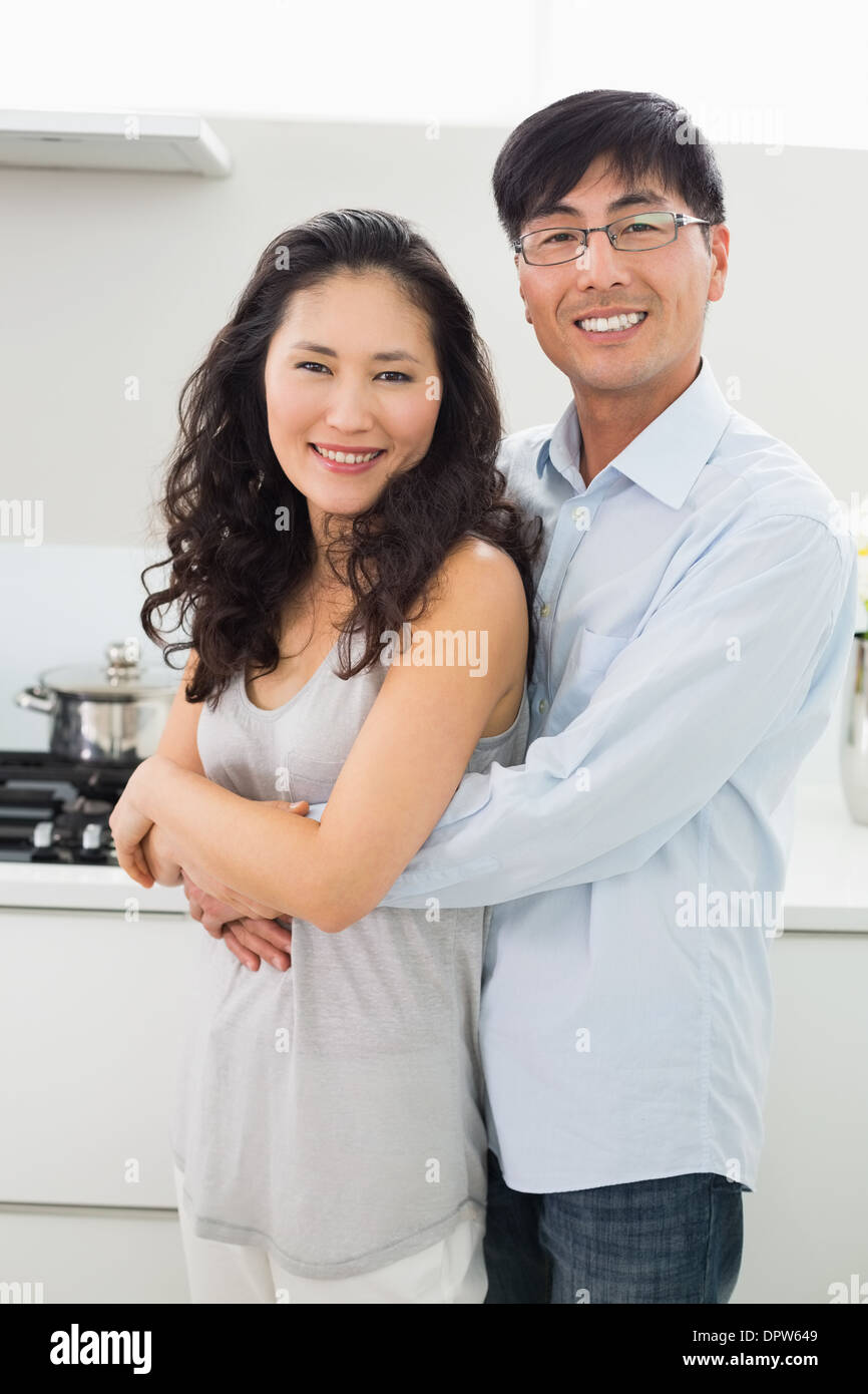Young man embracing woman from behind in kitchen Stock Photo - Alamy