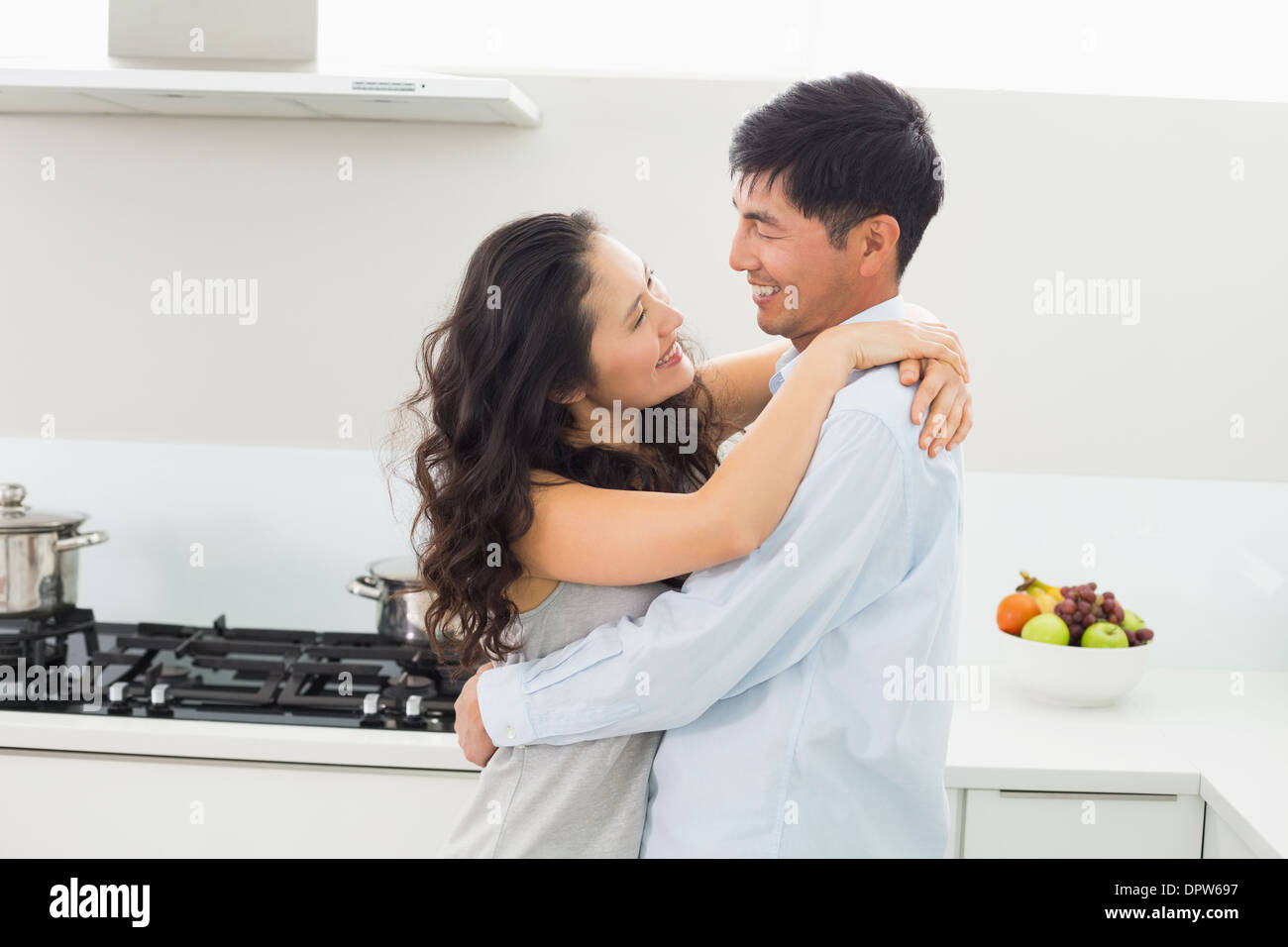 Side view of a man embracing woman in kitchen Stock Photo - Alamy