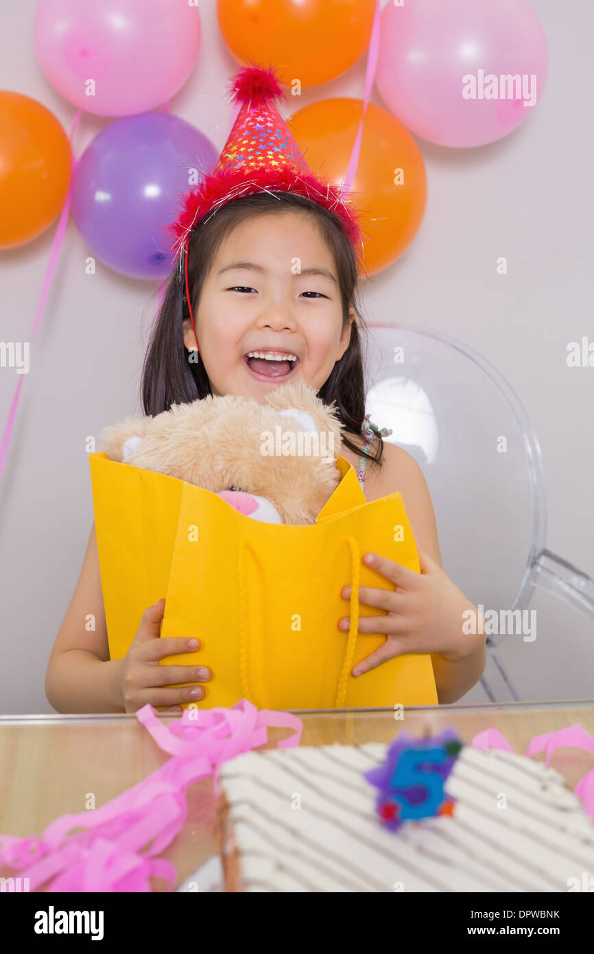 Cheerful surprised little girl at her birthday party Stock Photo