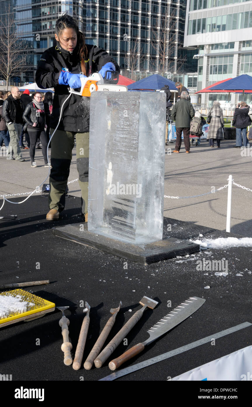 London Ice Sculpting Festival 2014 at Canary Wharf. Ice sculpting hand tools and chainsaw - Anne Marie Taberdo (British Team) Stock Photo