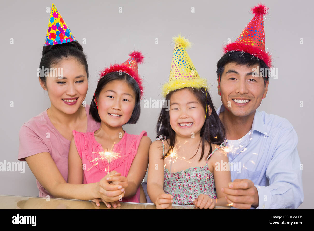 Family of four playing with firecrackers at a birthday party Stock Photo