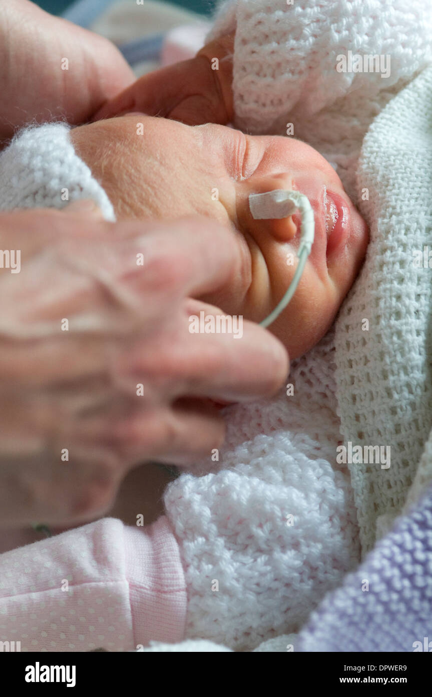 Premature newborn baby girl in hospital with a feeding tube attached to