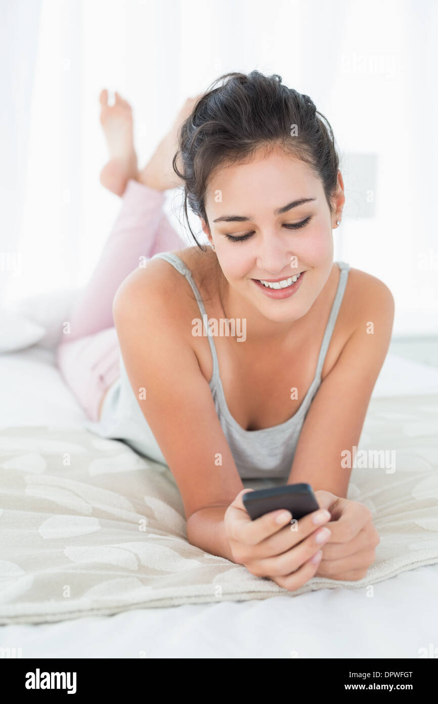 Relaxed woman looking at mobile phone in bed Stock Photo