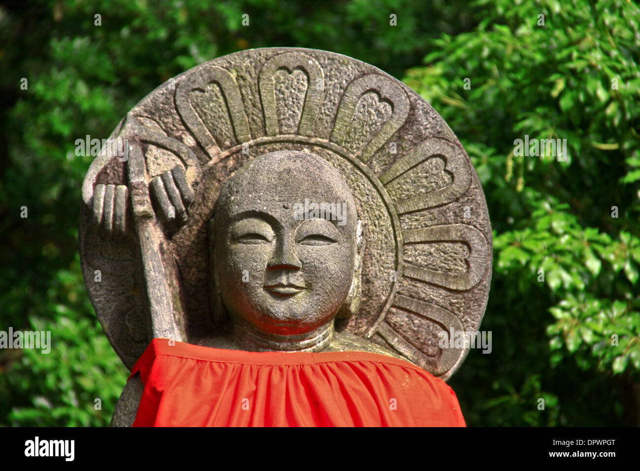 An Ojizo-sama statue, dressed in a red bib, near Todaiji Temple, Nara Park, Japan. Stock Photo