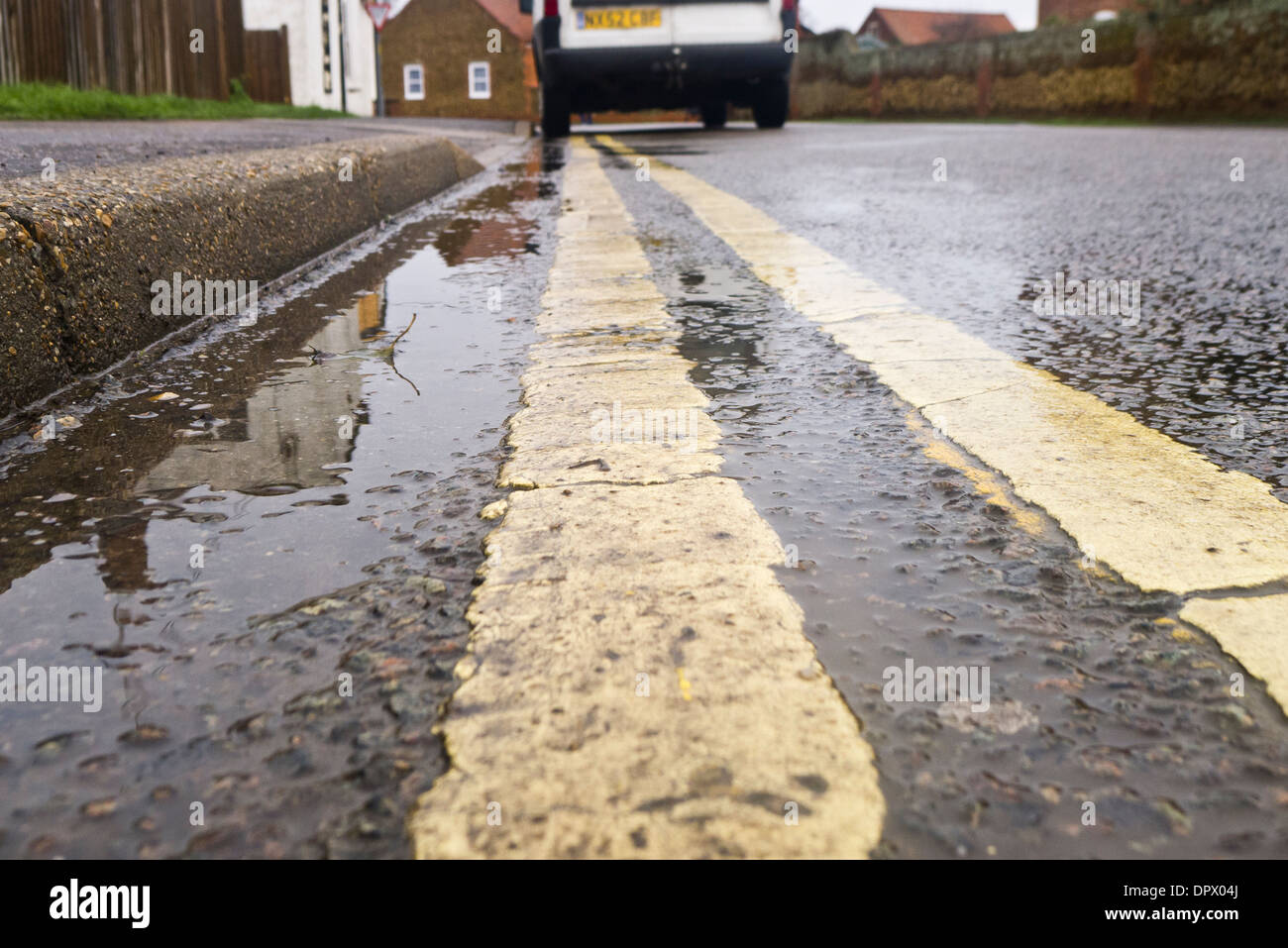 Double yellow lines and a white van parked illegally. Stock Photo