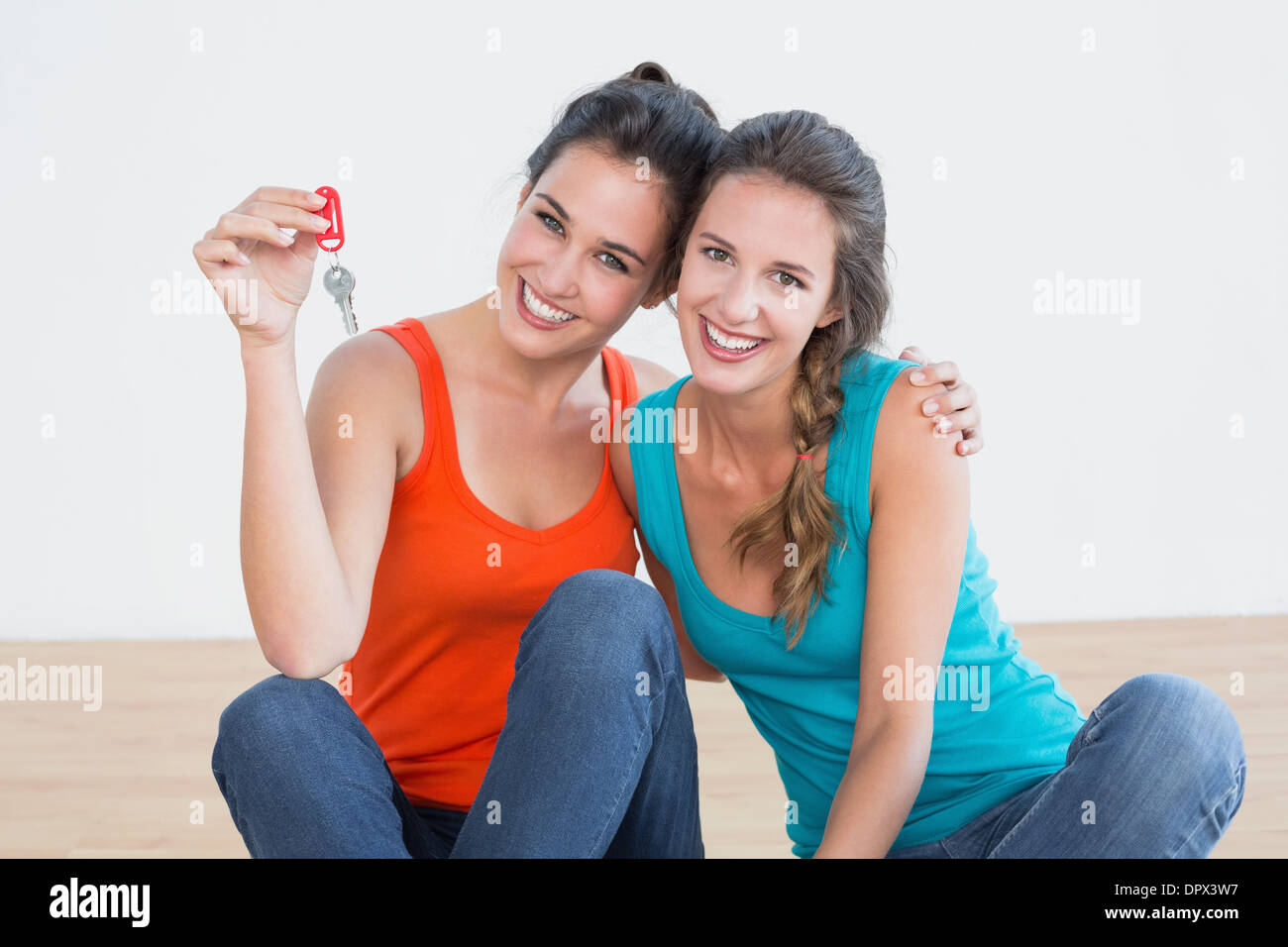 Friends with house keys sitting on the floor Stock Photo