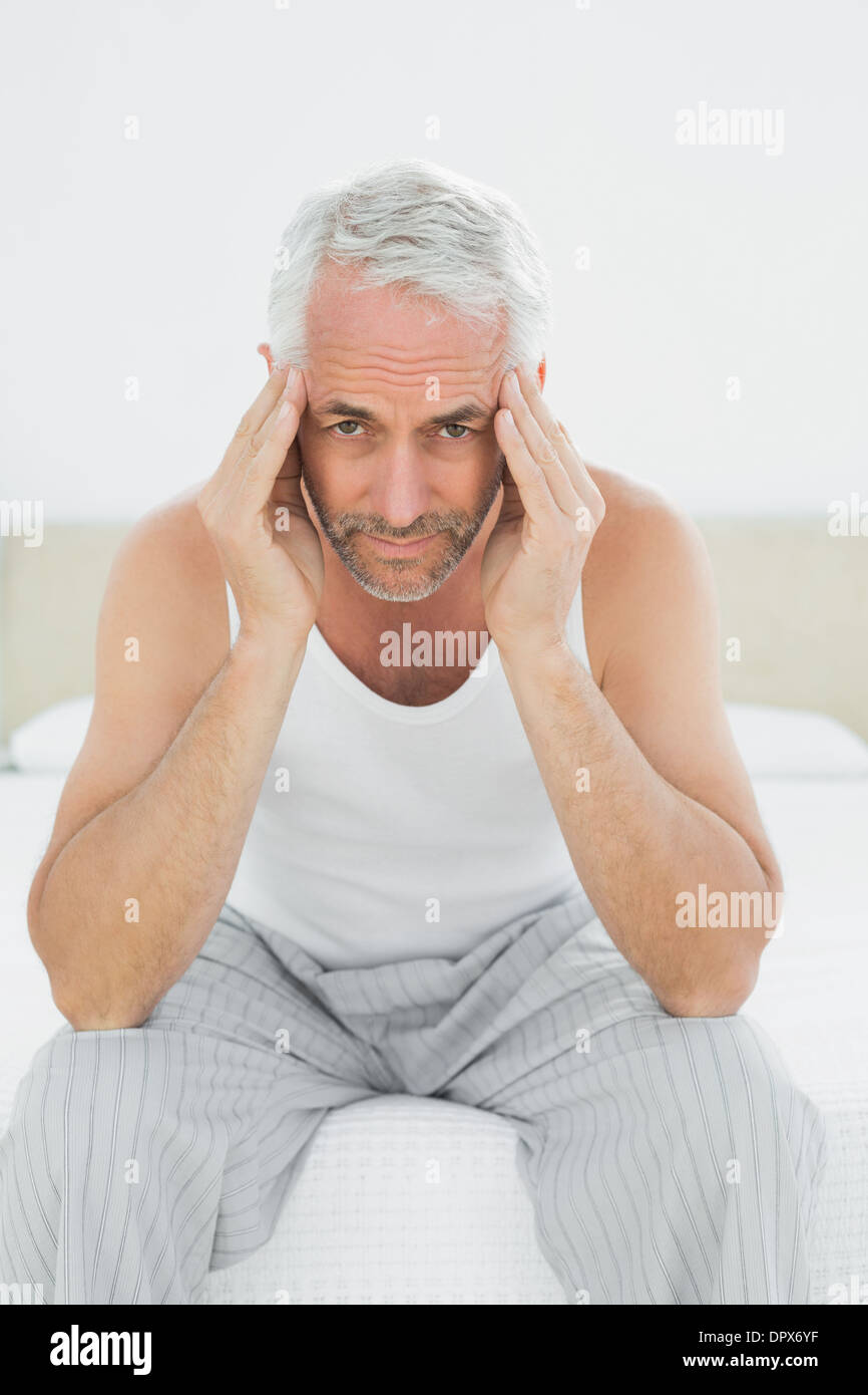 Mature man suffering from headache in bed Stock Photo