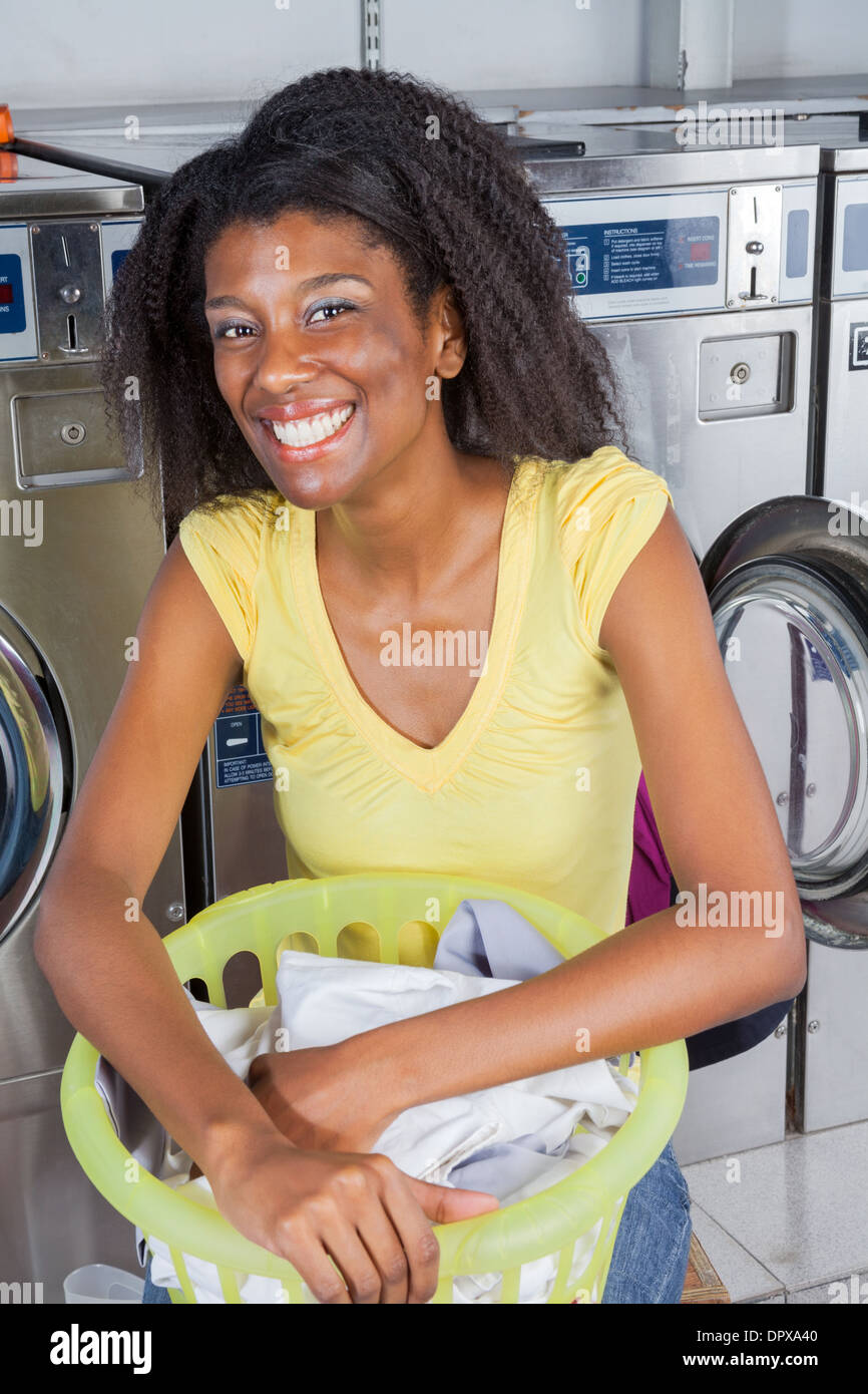Woman With Basket Of Clothes In Laundromat Stock Photo Alamy