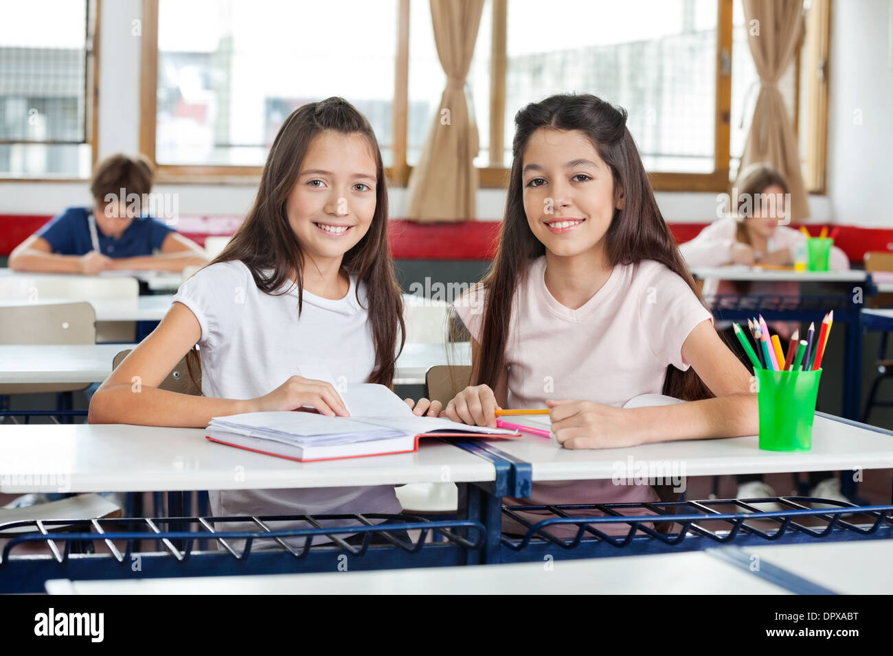 Portrait Of Happy Schoolgirls Sitting Stock Photo - Alamy
