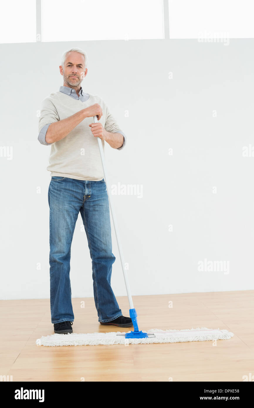 Full length portrait of a mature man standing with a mop Stock Photo