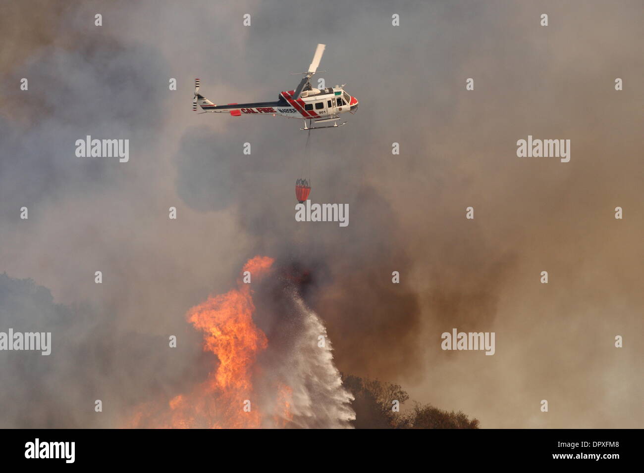 Glendora, California, USA. 16th January 2014. A large wildfire burns out of control in the hills above Glendora. Firefighters, helicopters and aircraft from many jurisdictions work to control the blaze. Credit:  Nicholas Burningham/Alamy Live News Stock Photo