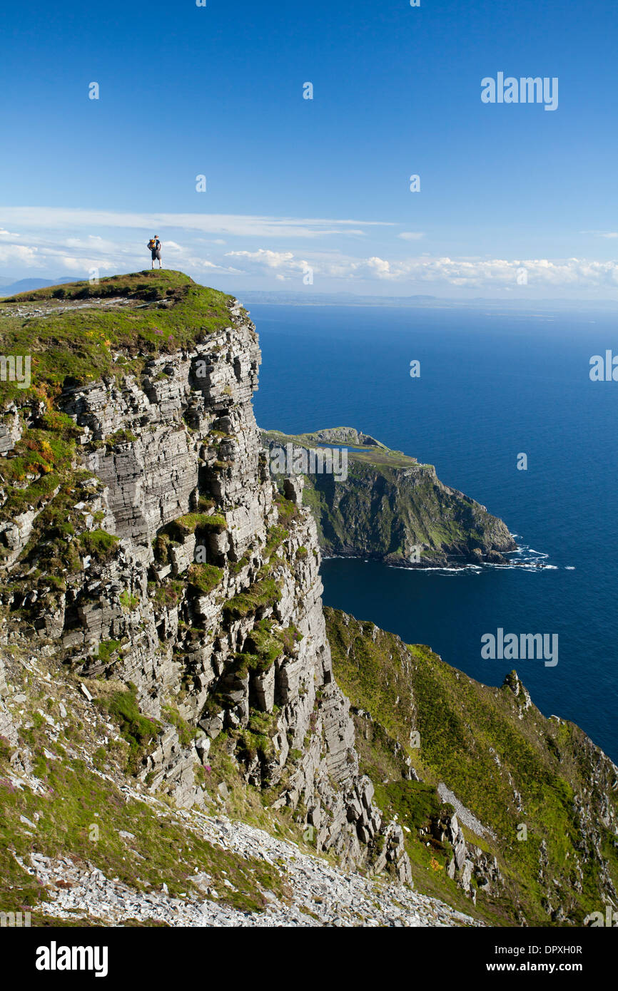 Walker looking towards Bunglas from close to the summit of Slieve League, County Donegal, Ireland. Stock Photo