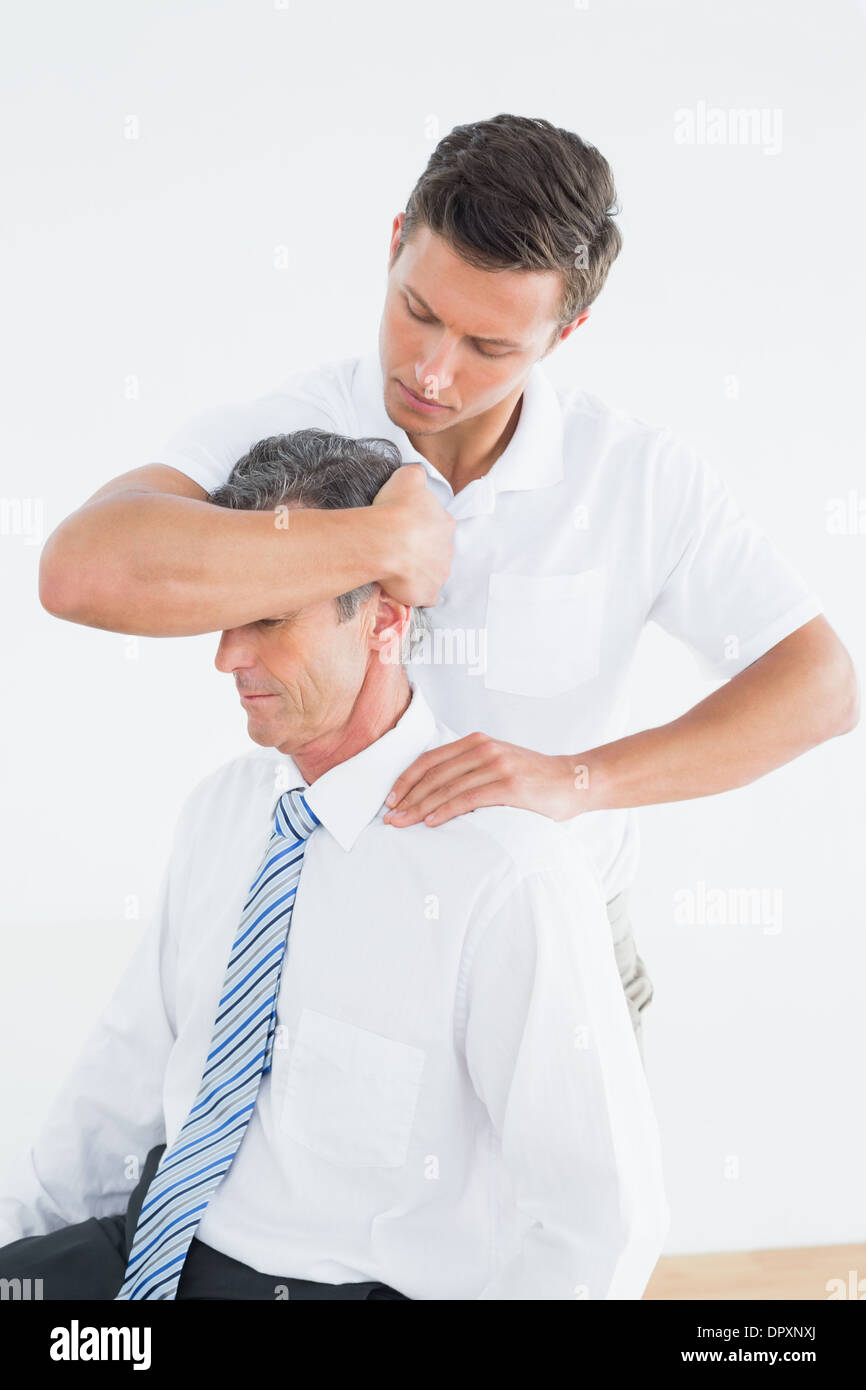 Male chiropractor doing neck adjustment Stock Photo - Alamy