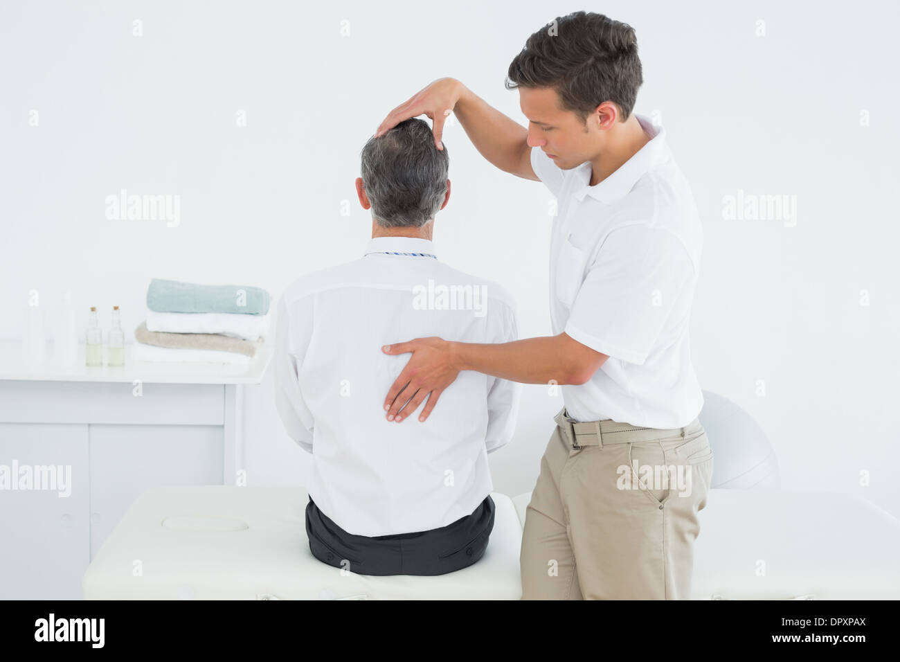 Male chiropractor examining mature man Stock Photo Alamy