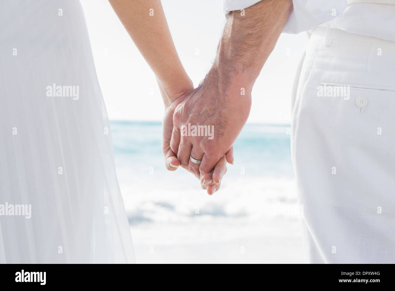 Bride and groom holding hands close up Stock Photo