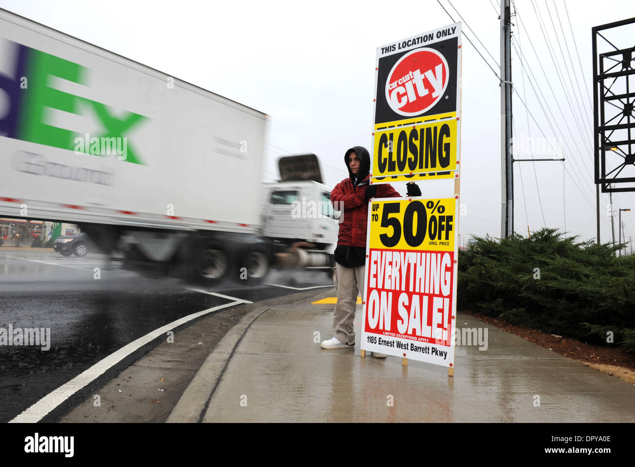 Dec 04, 2008 - Kennesaw, Georgia, USA - MICHAEL KRAMER, 19, stands in cold December drizzle holding sign advertising Circuit City store closing sale. The chain is shuttering 155 stores in the US, citing waning consumer confidence and a significantly weakened retail environment. (Credit Image: © Robin Nelson/ZUMA Press) Stock Photo