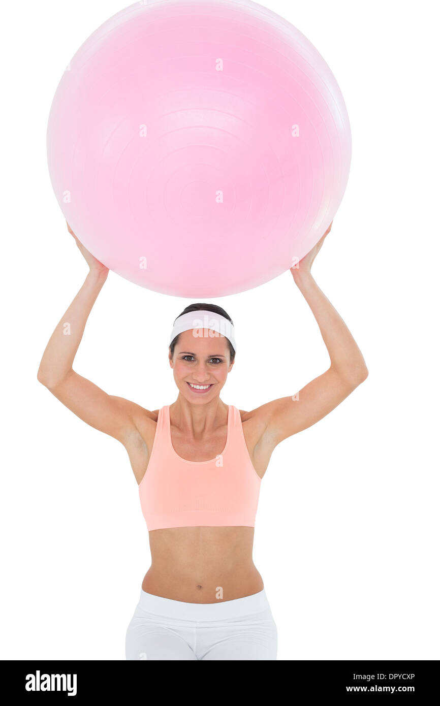 Portrait of a smiling fit woman holding up fitness ball Stock Photo - Alamy