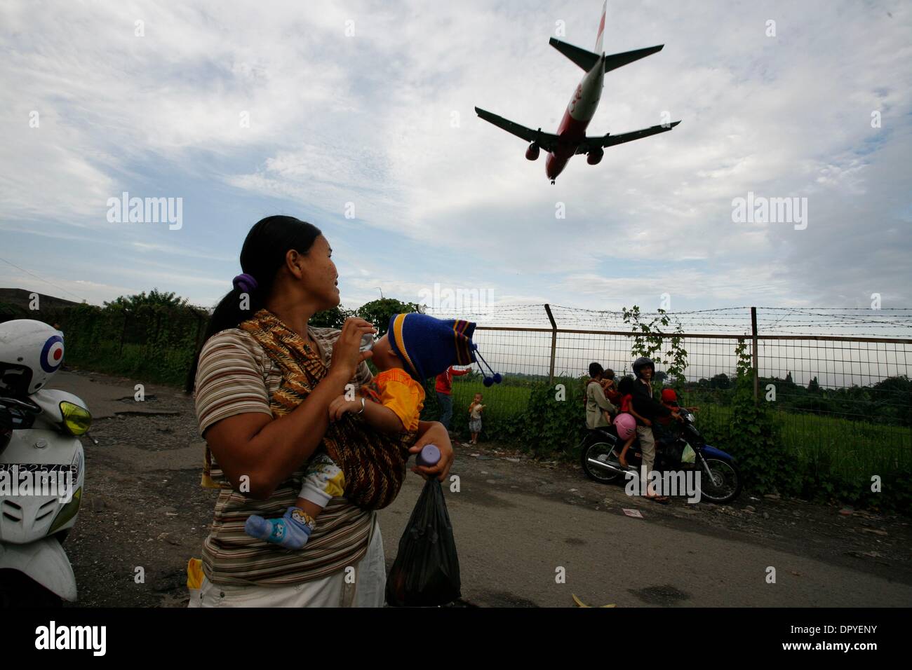 Feb 24, 2009 - Medan, North Sumatra, Indonesia - Visitors watching a commercial aeroplane crossed the airport border to landing on Medan, North Sumatra, Indonesia. Every afternoon, since the aeroplane crash on 2005 at this spot, hundreds people gathering to enjoying take off â€“ landing view of aeroplane of Medan Polonia Airport. Even risking their life, this view still amazed them Stock Photo