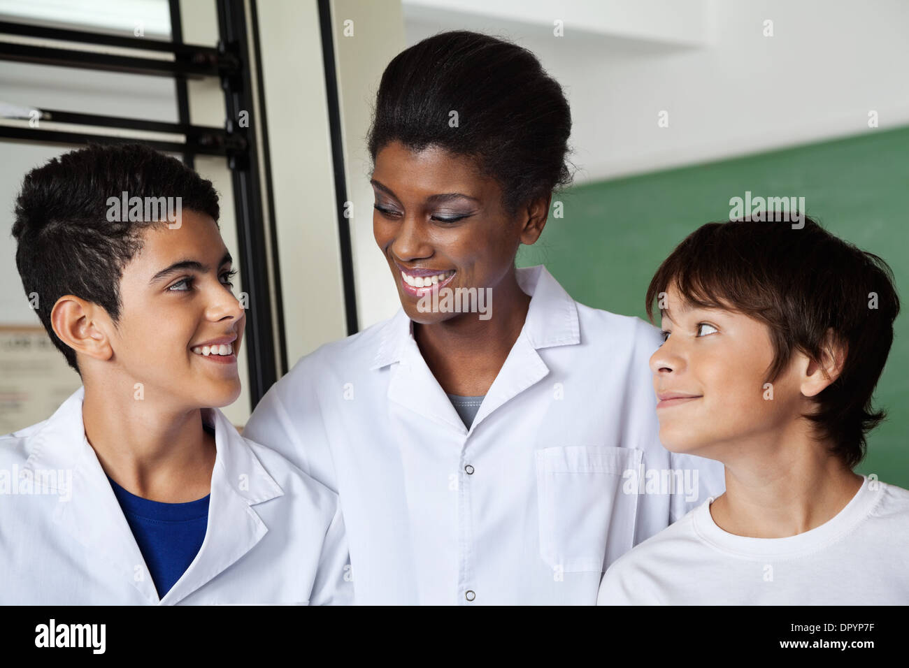 Teacher Looking At Schoolboy In Science Lab Stock Photo