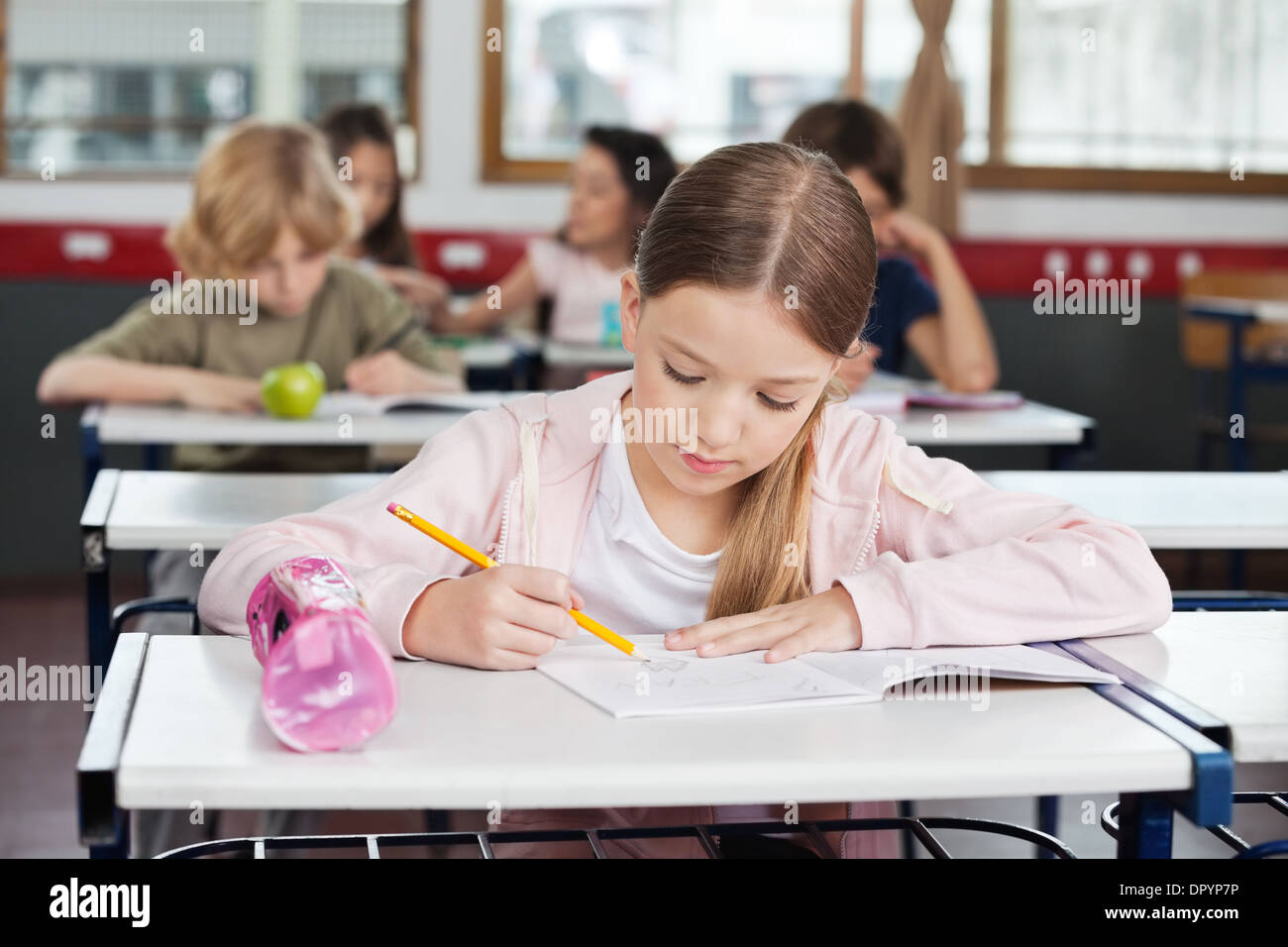 Schoolgirl Drawing In Book At Classroom Stock Photo - Alamy