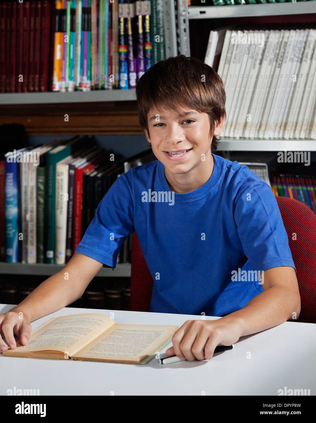 Teenage Male Student Sitting At Table In Library Stock Photo - Alamy