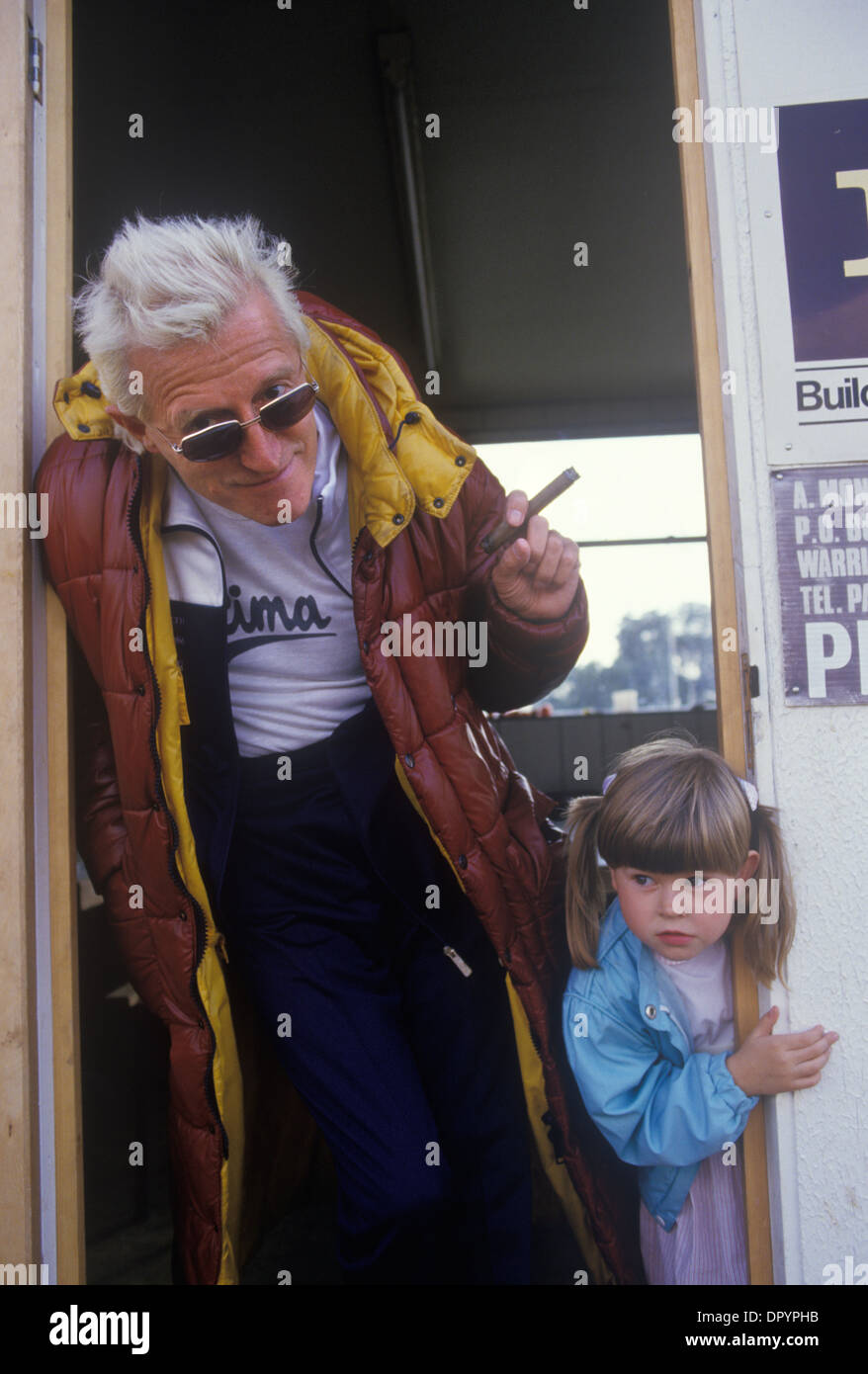 Jimmy Savile, British entertainer & disc jockey, TV & radio broadcaster with a pre-teen girl child. He is smoking his trademark cigar. Late1980s or early 1990s, Roundhay, Leeds UK  HOMER SYKES Stock Photo
