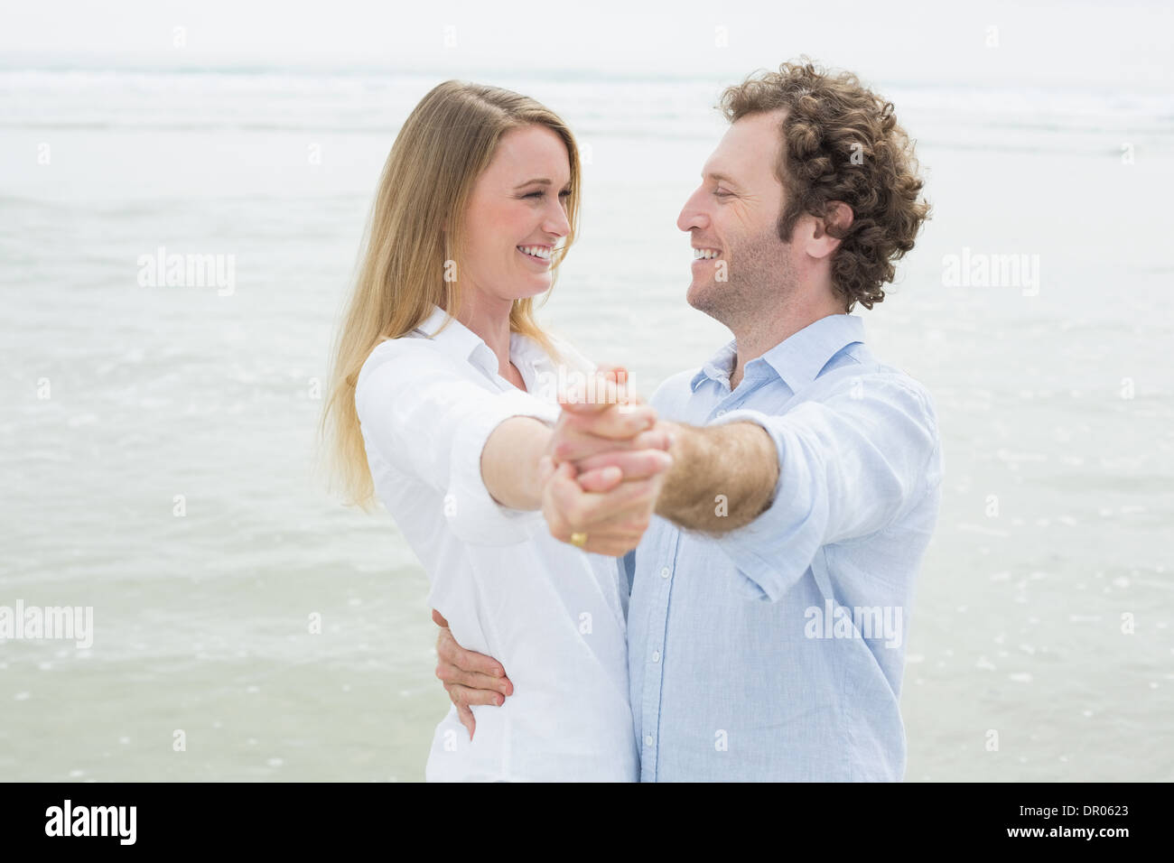 Happy young couple dancing at beach Stock Photo - Alamy