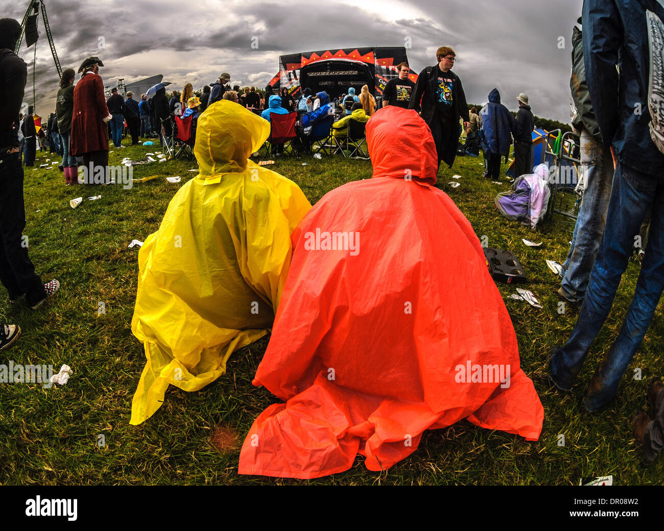 Leeds Festival - crowd. 2 people in foreground wearing waterproof ponchos. Stock Photo