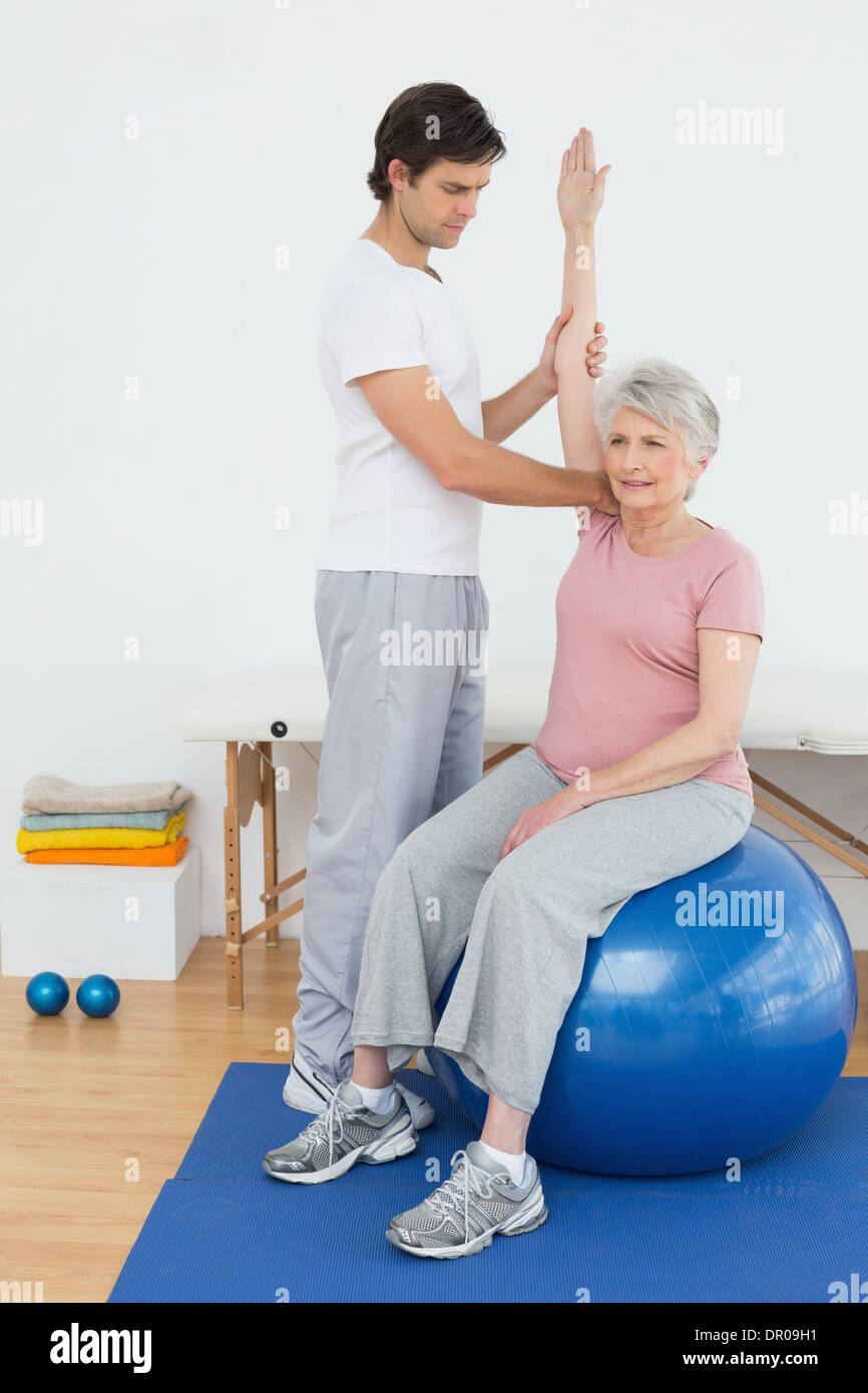 Senior woman on yoga ball with a physical therapist Stock Photo