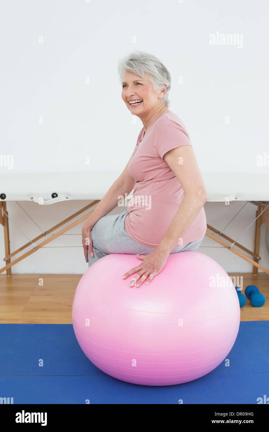 Rear view portrait of a senior woman sitting on yoga ball Stock Photo