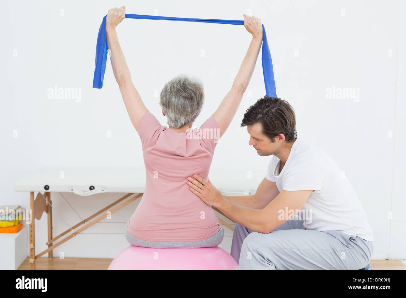 Senior woman on yoga ball with a physical therapist Stock Photo