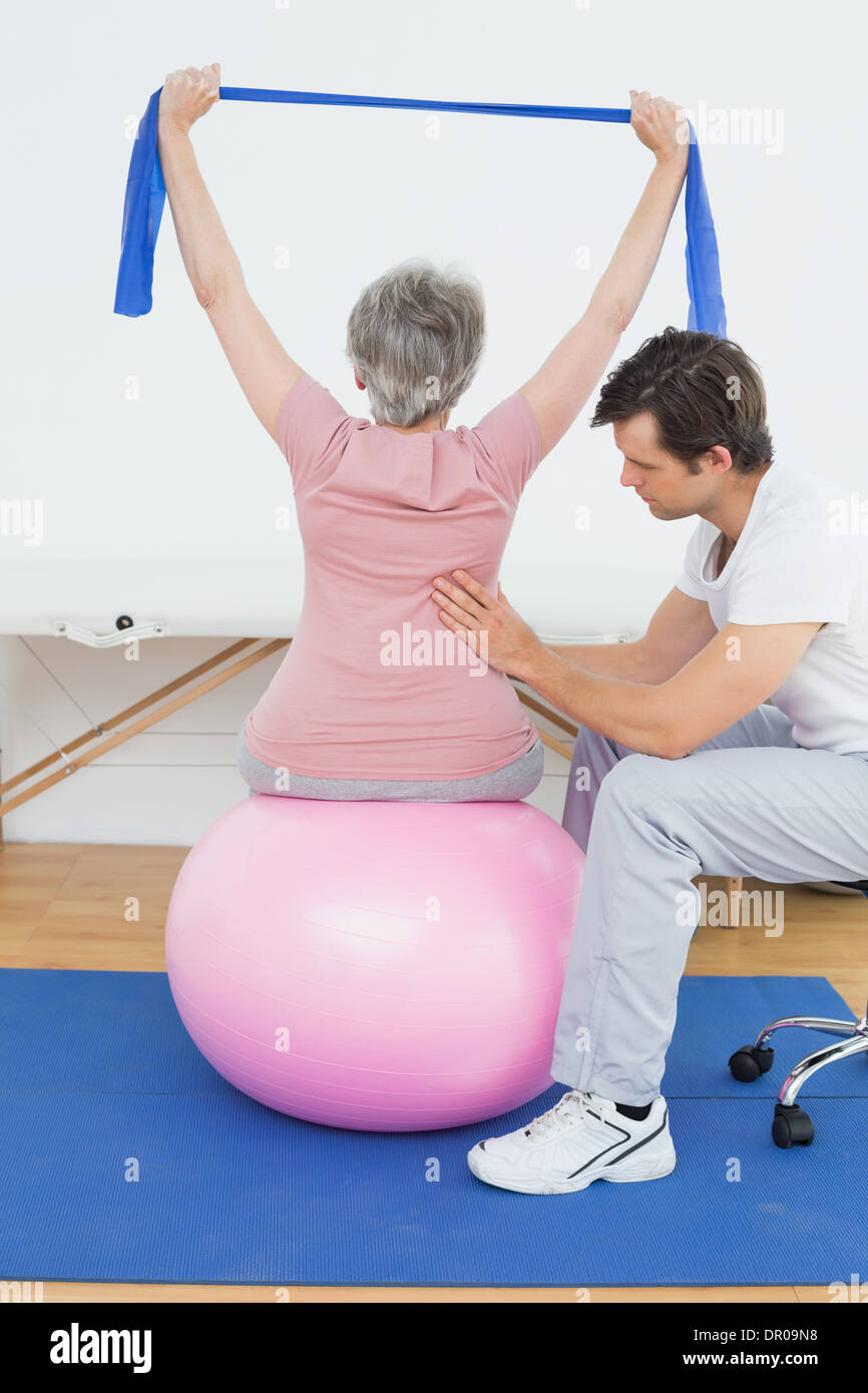 Senior woman on yoga ball with a physical therapist Stock Photo Alamy