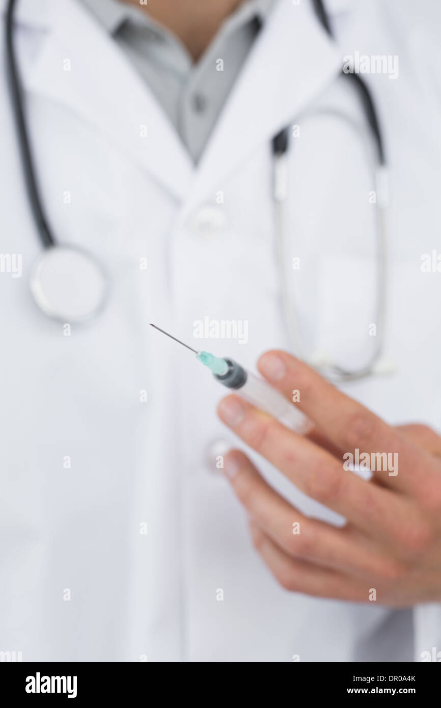Mid section of a male doctor holding an injection Stock Photo - Alamy