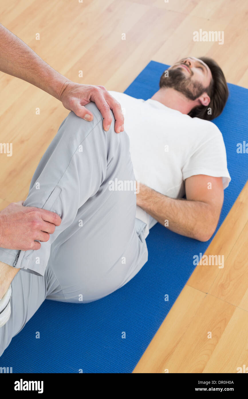 Physical therapist examining man's leg Stock Photo