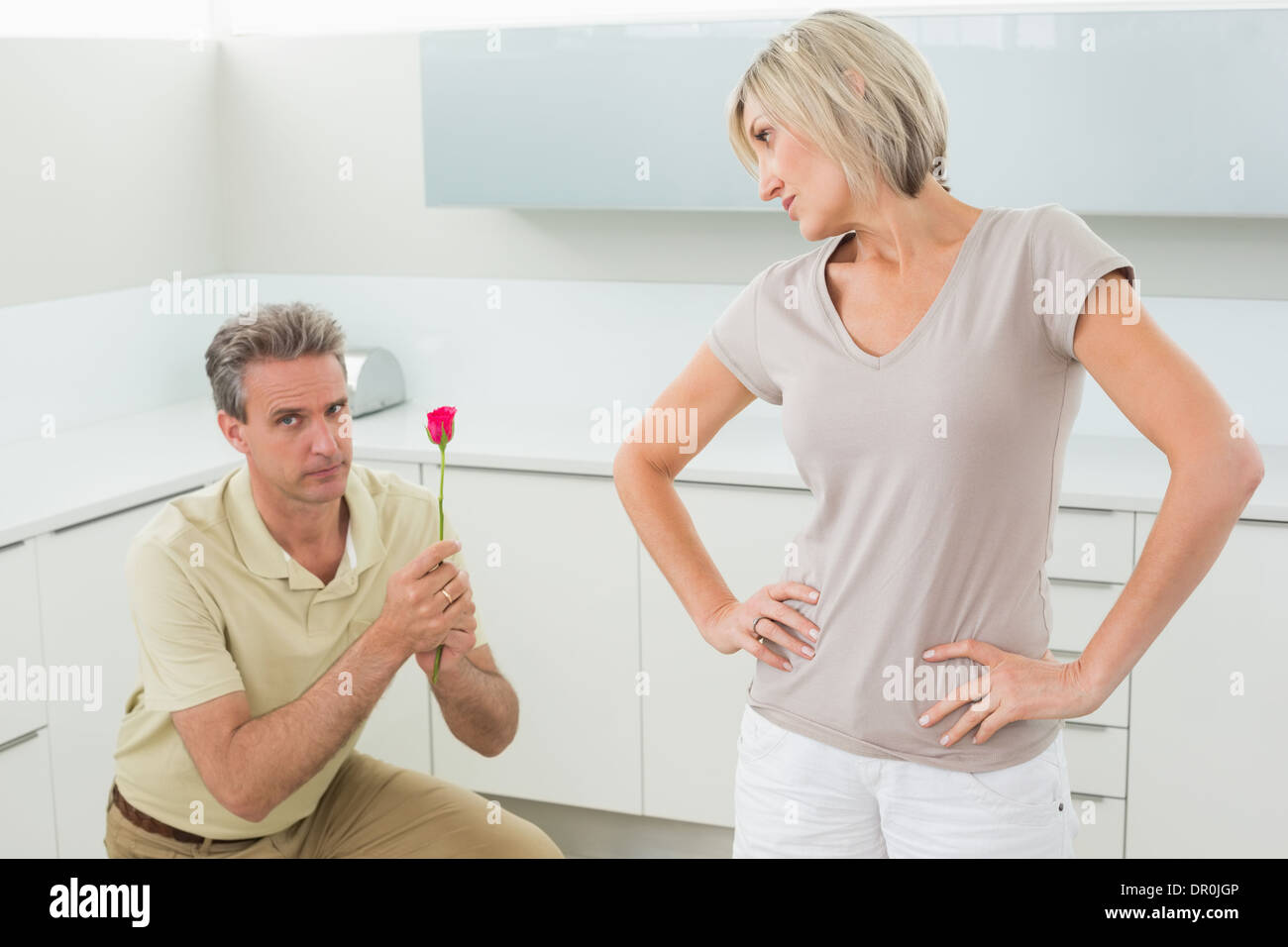 Man making a proposal to woman in kitchen Stock Photo