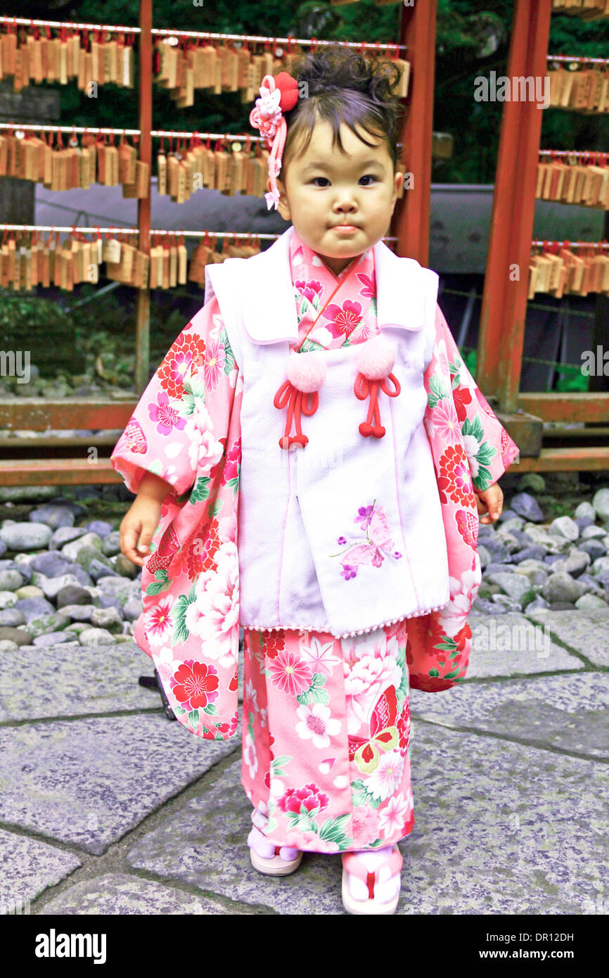 Japanese little girl dressed in traditional clothes near Futarasan jinja, a Shinto shrine, Nikkō, Japan. Stock Photo