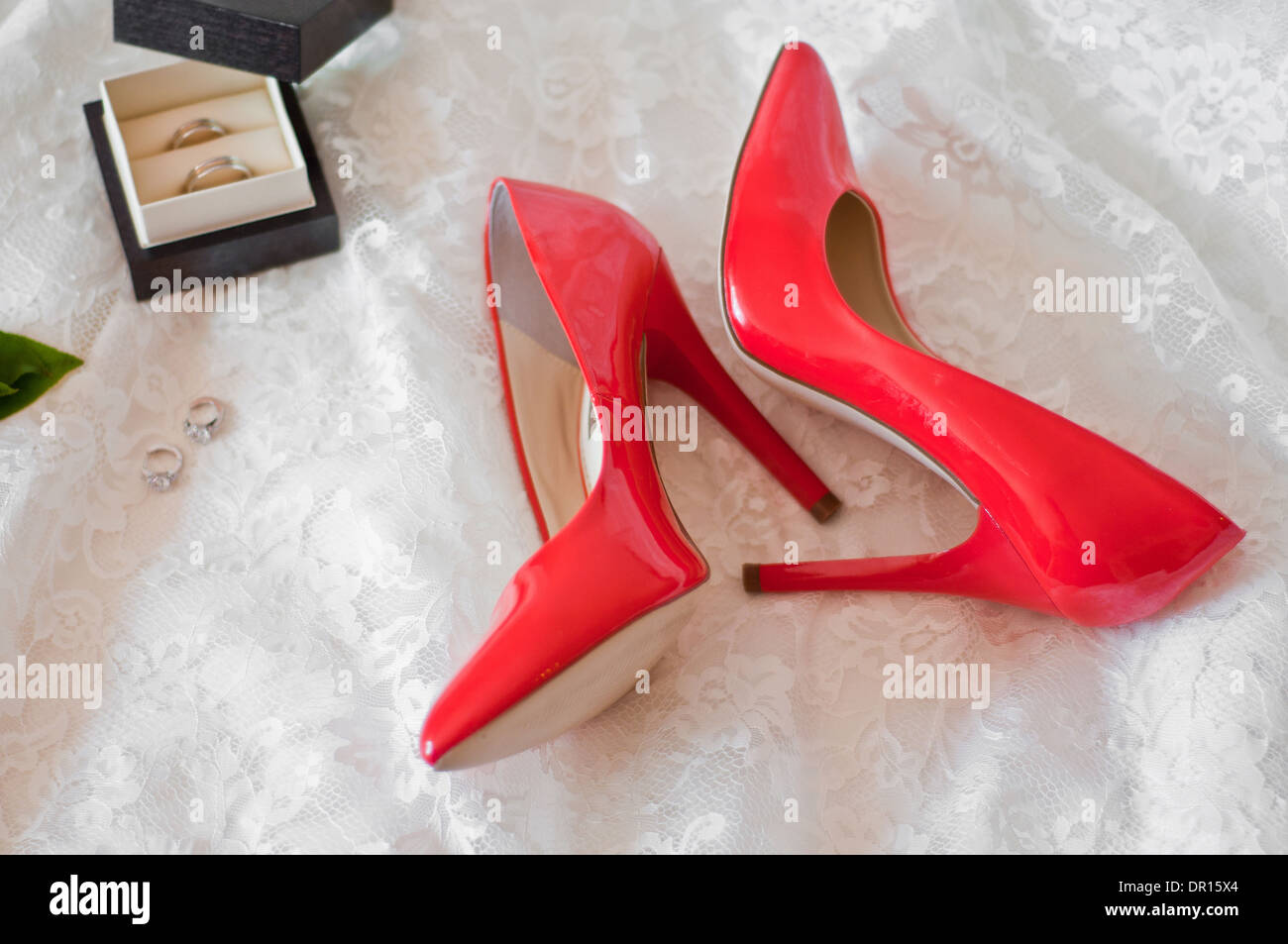 Red Shoes And Earrings Of The Bride And Also Wedding Rings On A